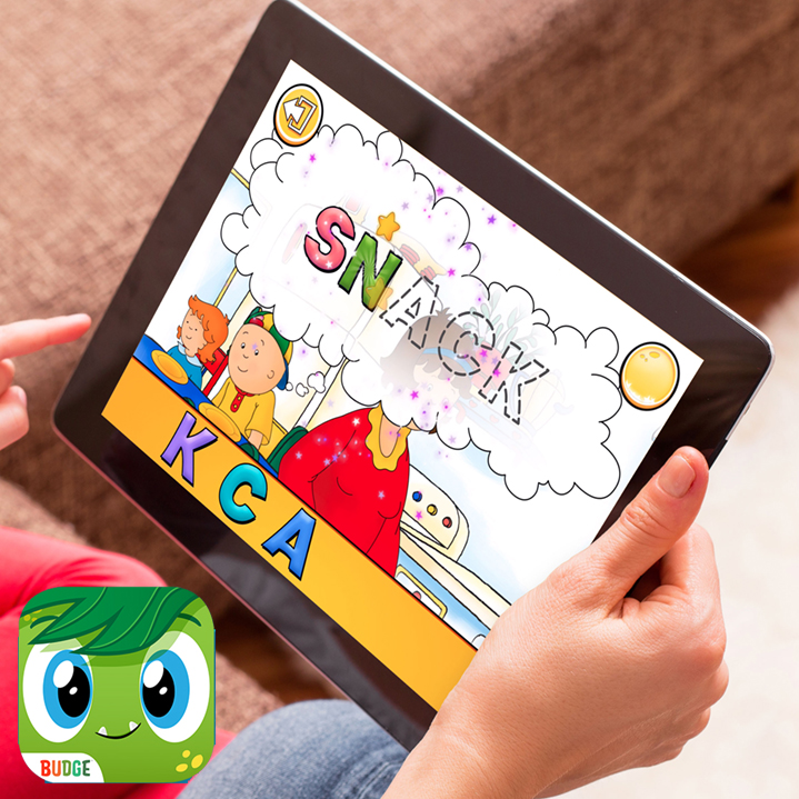 A hand holding a tablet with a children's game on the screen.